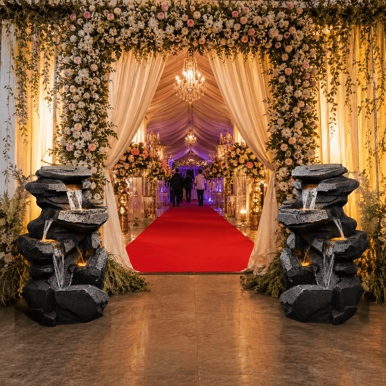 Rock-style fiber fountains flanking a red carpet entrance with floral drapes